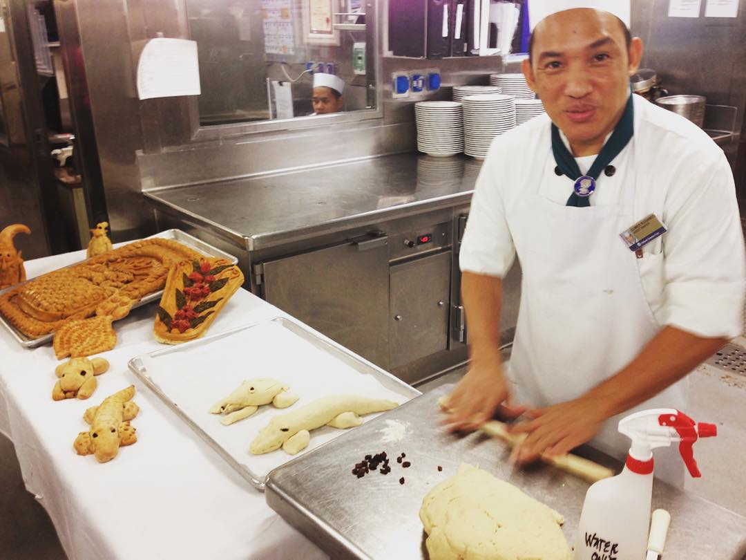 A galley crew member works on a bread display in the galley of the Zuiderdam