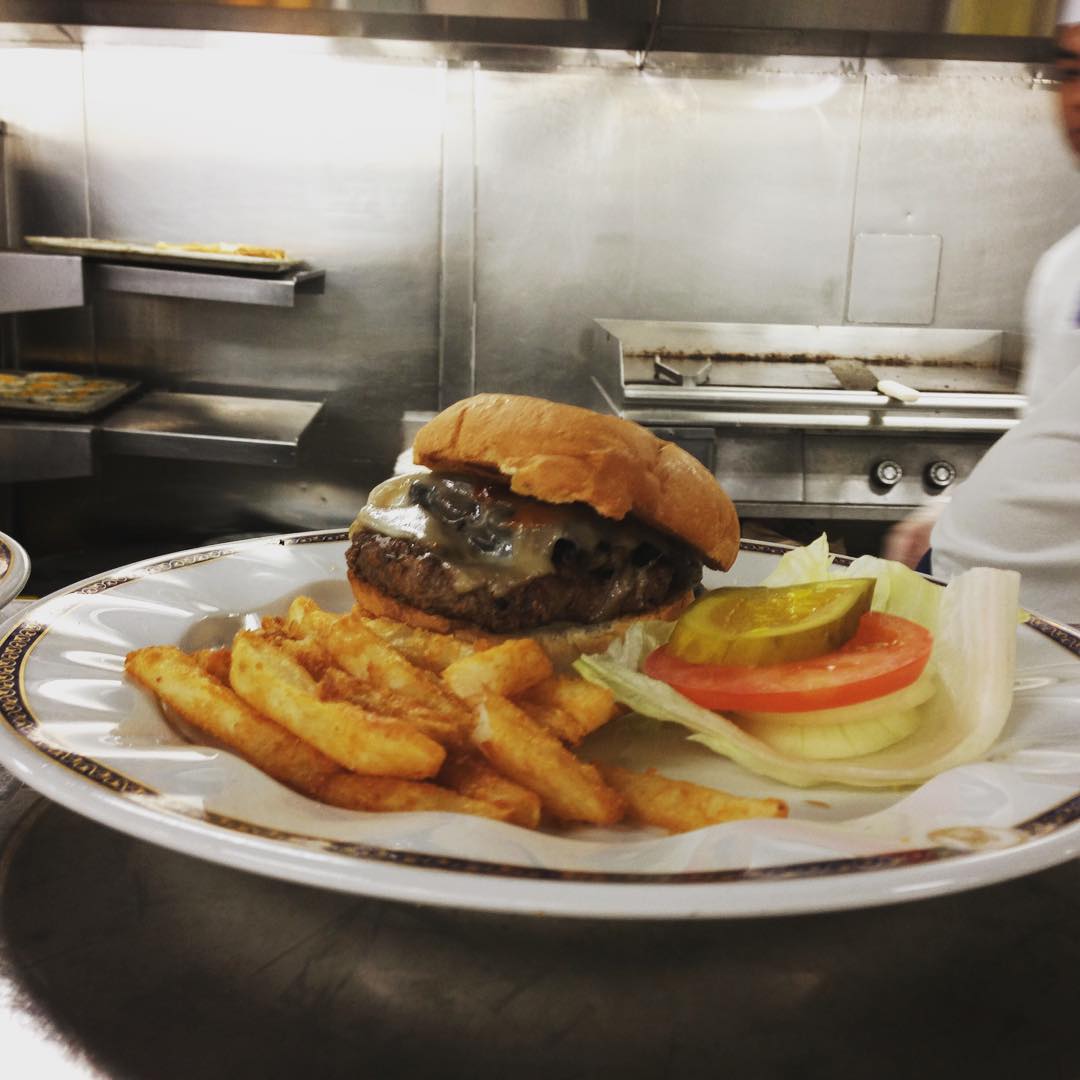 A room service burger is plated up and ready to go in the galley of the Zuiderdam