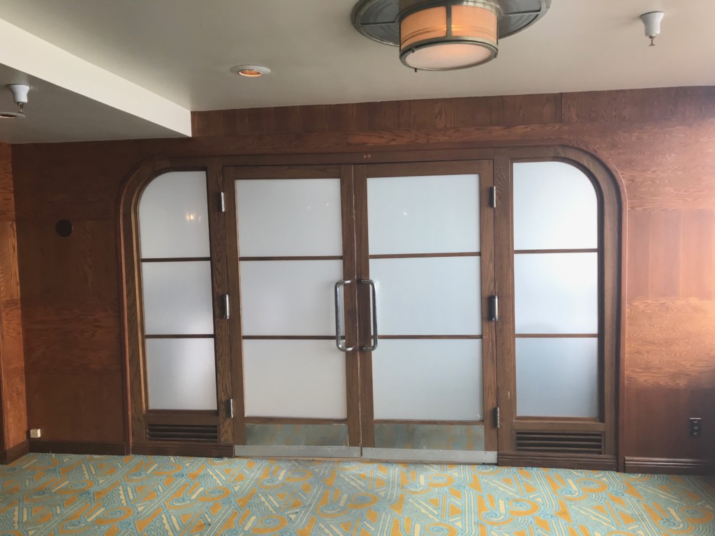 A stylish door with frosted windows and an art deco frame in the Royal Salon on the Queen Mary