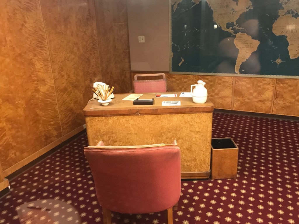 A desk in the first class Travel Bureau on the Queen Mary where passengers would sit and talk to ship staff about a future voyage