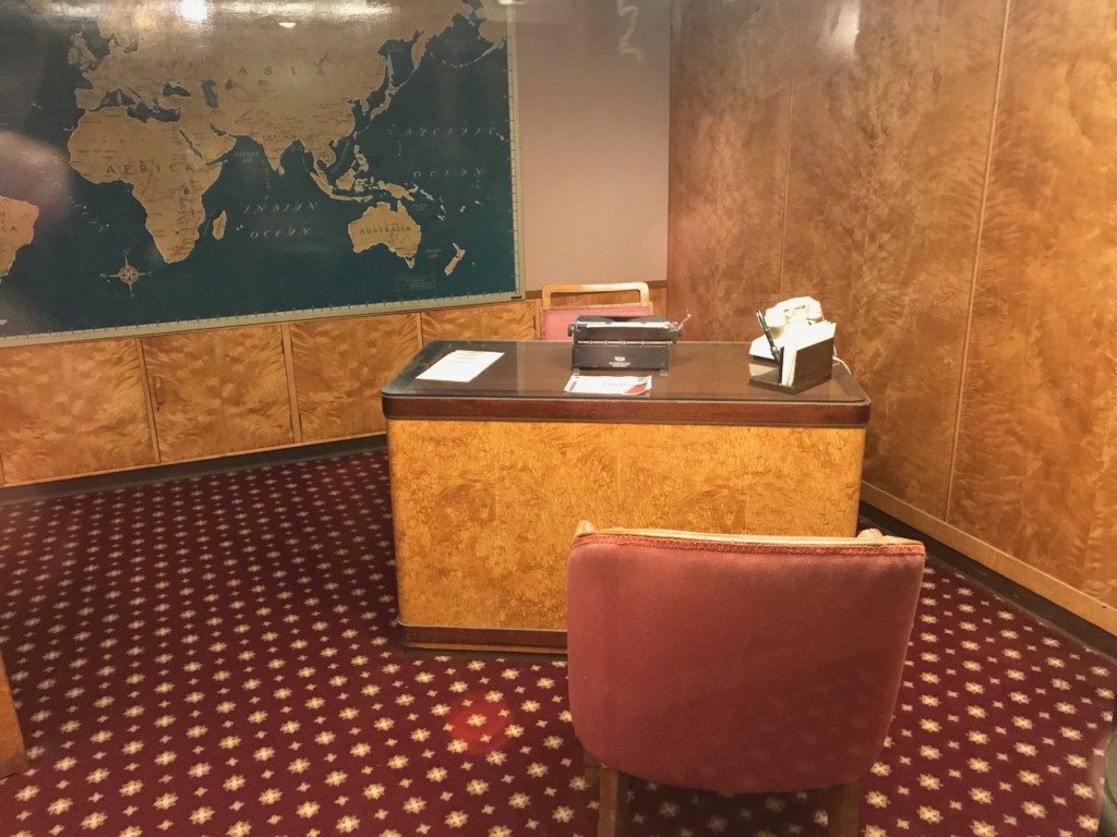 A desk in the first class Travel Bureau on the Queen Mary where passengers would sit and talk to ship staff about a future voyage