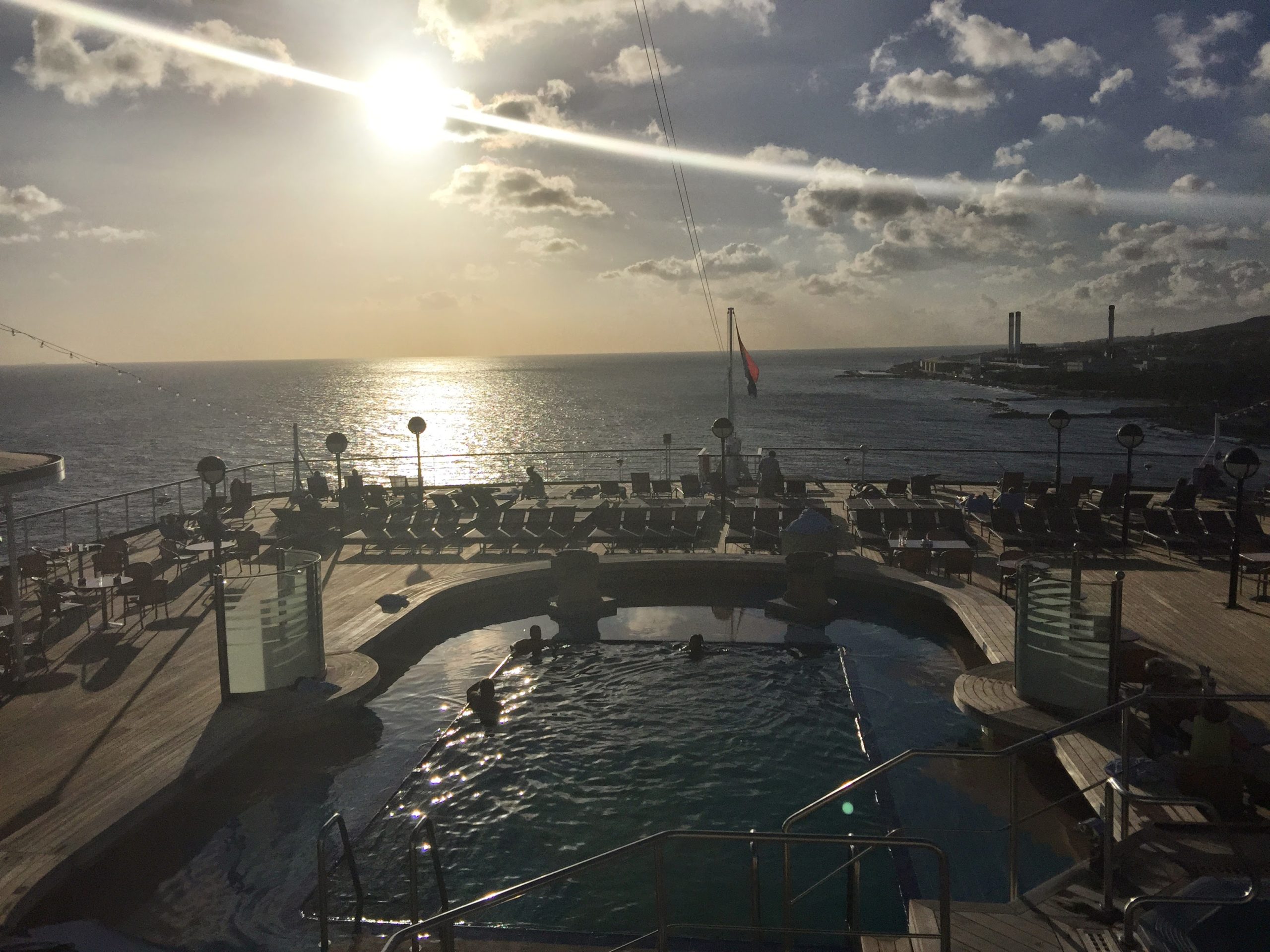 The sun sets while some enjoy the Sea View Pool on Noordam