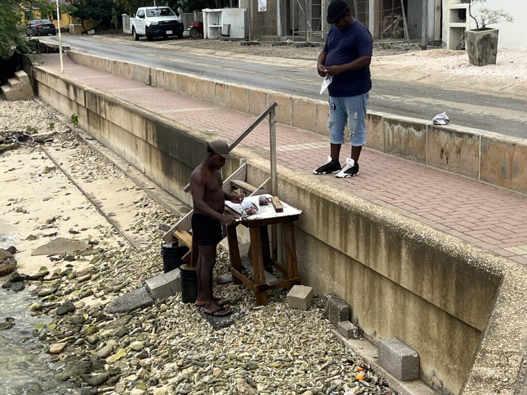 A local fisherman cutting up fish along the shore in A new floating pier in Kralendijk, Bonaire