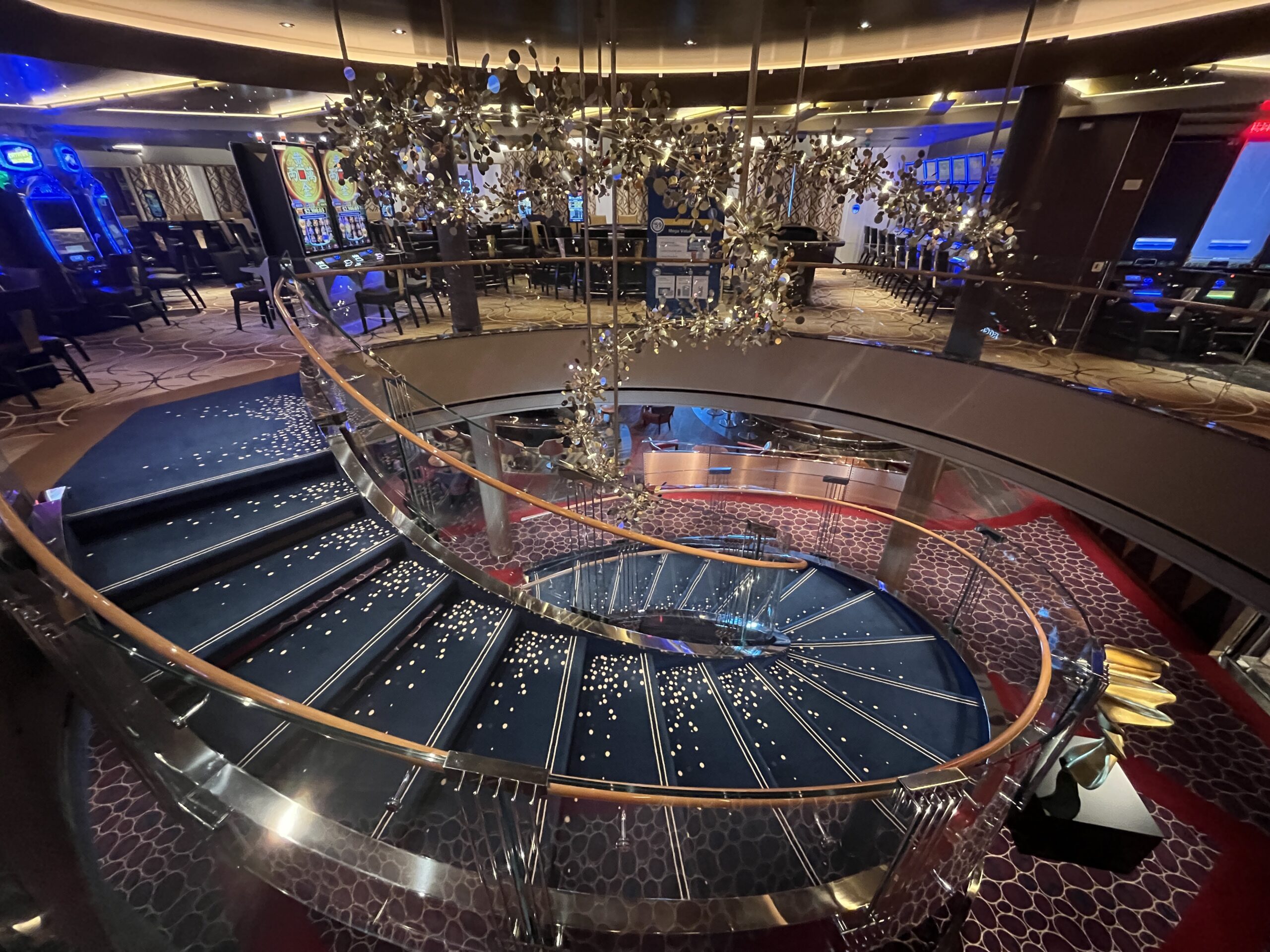 This staircase on Rotterdam connects the Rolling Stone Lounge and Billboard Onboard located on deck 2 to the casino on deck 3. It's rumored to be removed during dry dock.