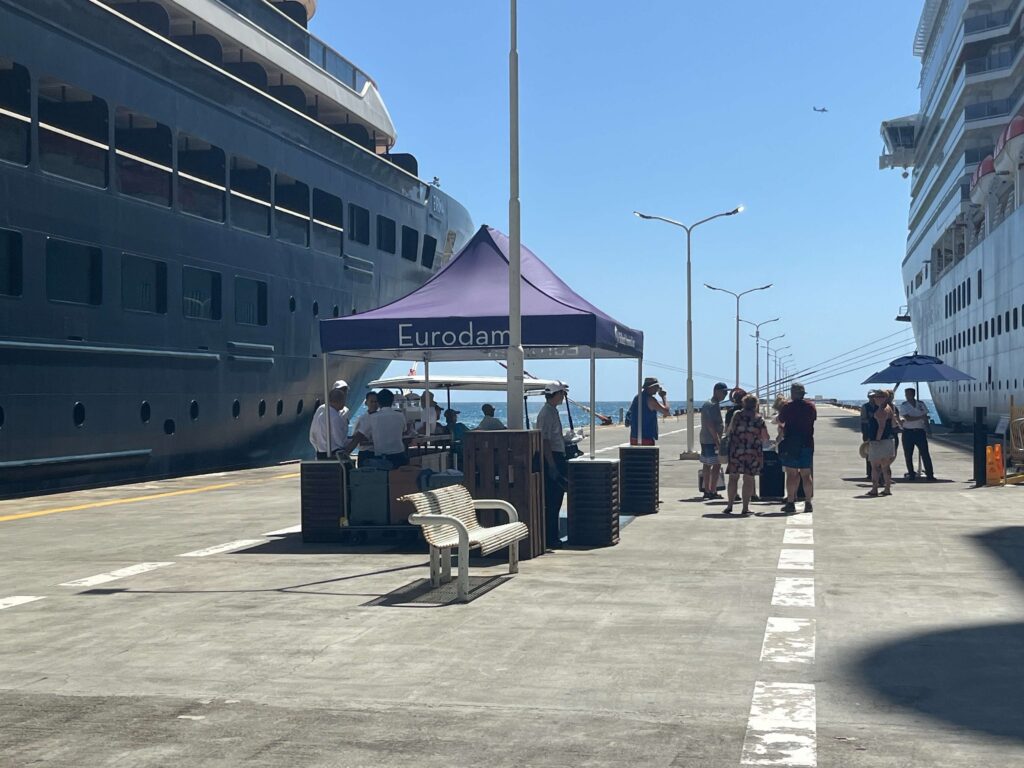 The Eurodam crew welcoming passengers back to the ship with cold face towels and water.