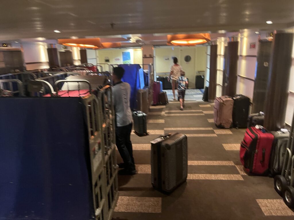 Crew members collecting luggage to be taken off the ship for debarkation