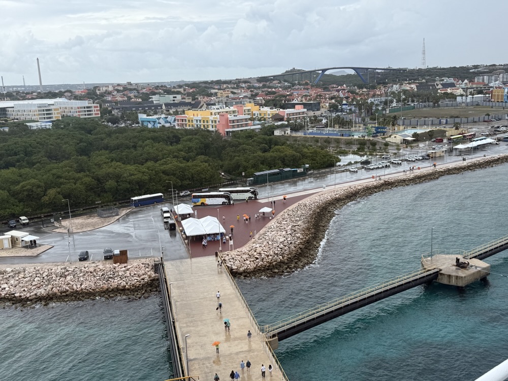 Passengers from the Rotterdam walking off the ship in Curacao... easily identified by the orange umbrellas!