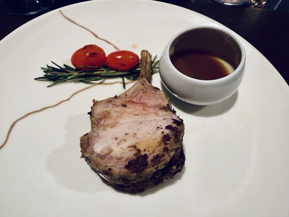 Iberico de Bellota roasted pork rack with Taggiasca olive crust from Marble & Company Grill on Explora Journeys