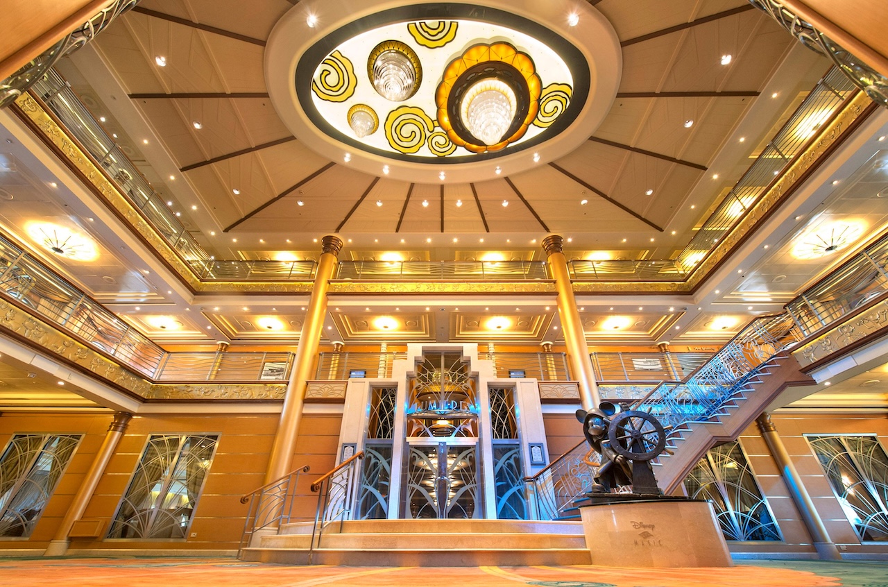 The grand atrium lobby on the Disney Magic, inspired by elegant art deco and elements of the sea, features a palette of vibrant coral, blue and aquamarine, a dazzling new chandelier and a grand staircase. Exuding the elegance of the early 20th century ocean liners, the lobby’s focal point is a cast bronze statue of Helmsman Mickey. (Kent Phillips, photographer)